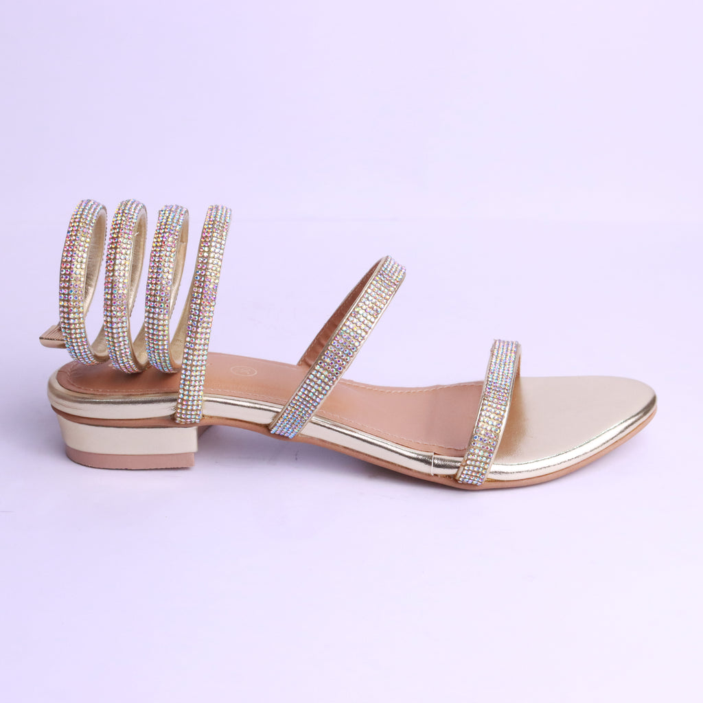 Red sandals with thin straps worn by a person on a wooden floor.
